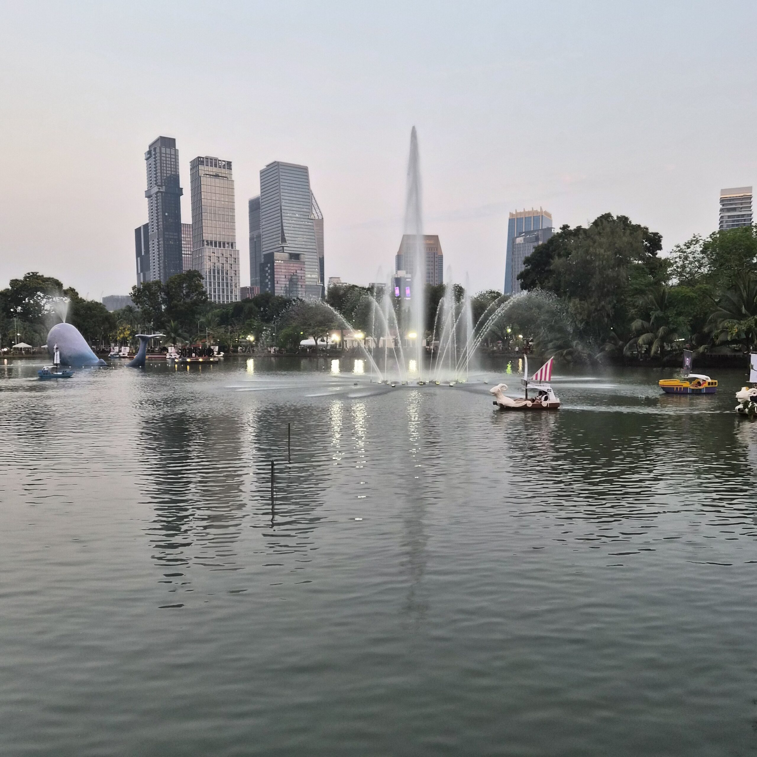 Le lac et sa fontaine au pied des tours de Bangkok, dans un parc du centre-ville