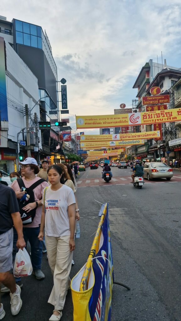 Motorbikes and passers-by under the Yaowarat banners