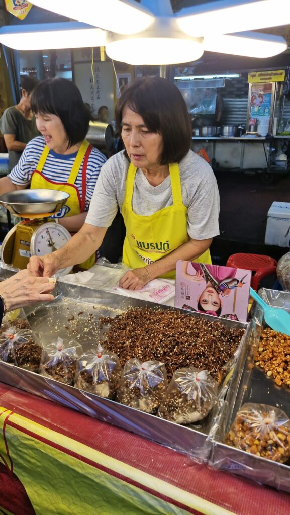 Vendor in a yellow apron preparing fried food