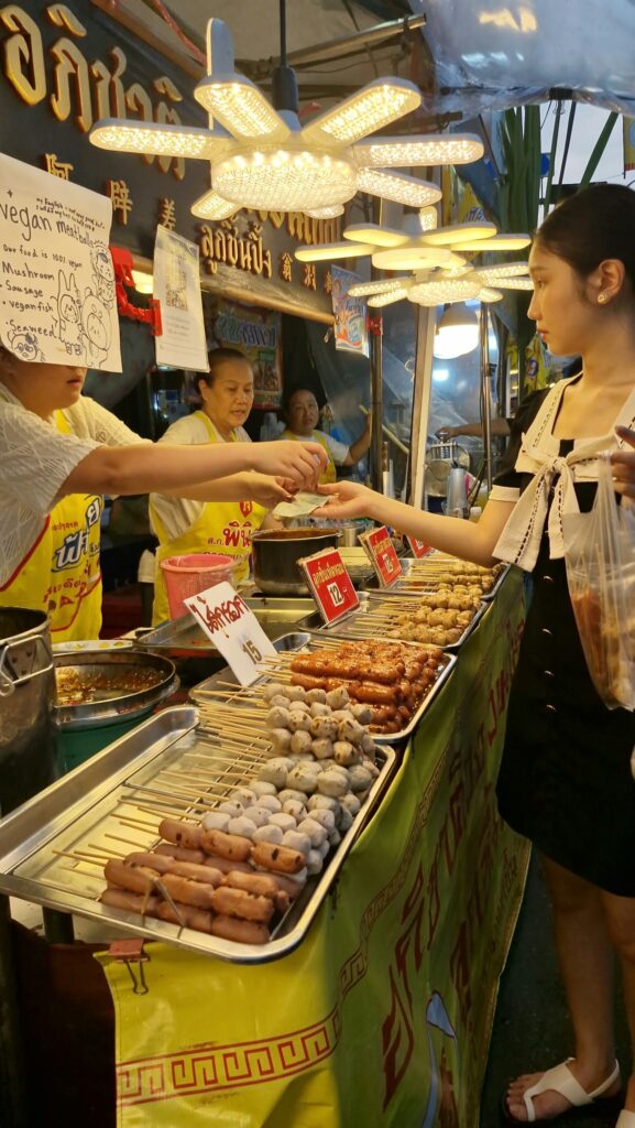 Vendor wrapping vegetarian skewers