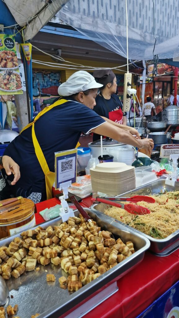 Cook in an apron on a Chinatown stall