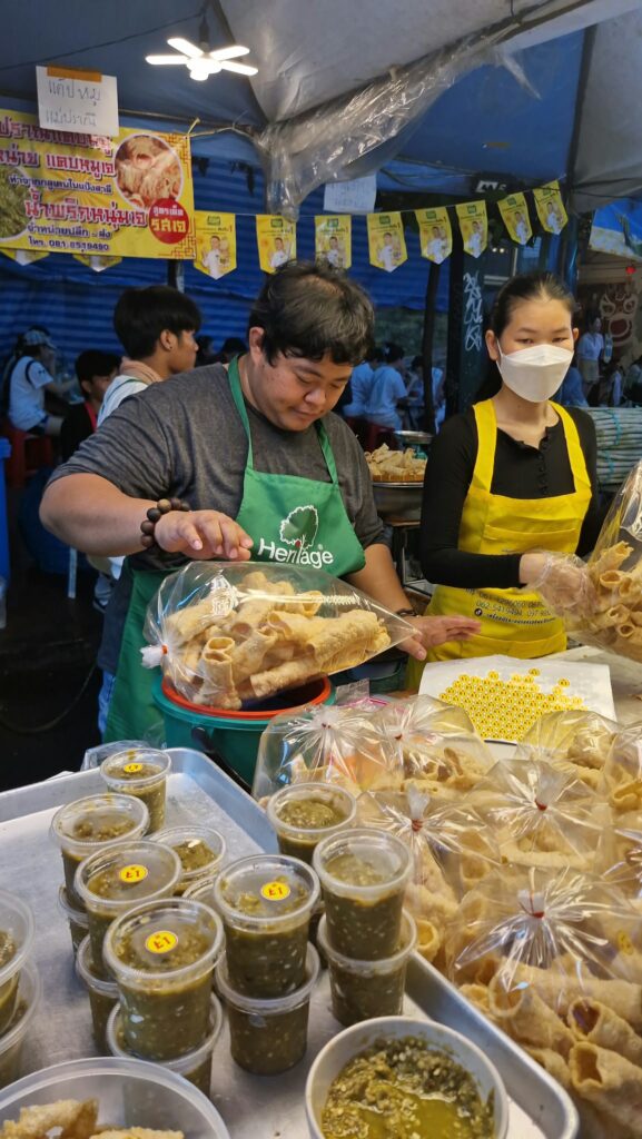 Masked vendors serving vegetarian dishes