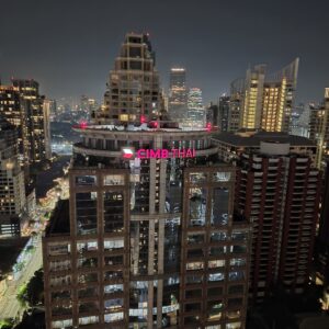 Gratte-ciel de Bangkok illuminés la nuit, vus d'un rooftop